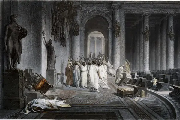 Die Ermordung Caesars: Senatoren mit erhobenen Dolchen umringen den gefallenen Diktator. Ein umgestürzter Stuhl und eine Leiche auf dem Boden zeugen vom brutalen Ende.