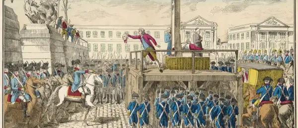 Ein Mann hält einen Kopf hoch, während die Guillotine in Frankreich bereitsteht. Soldaten und eine Menge beobachten die Hinrichtung.